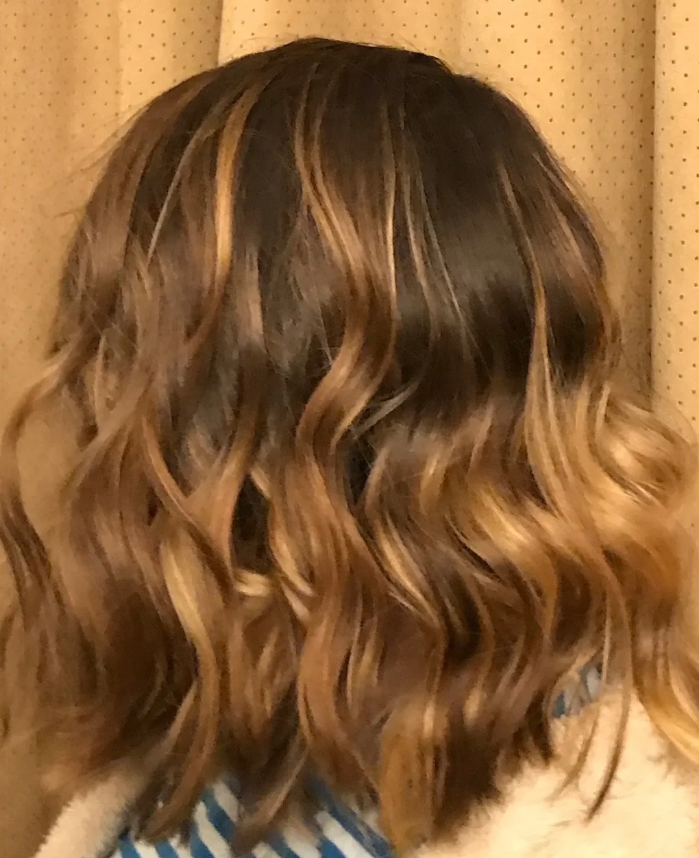 Warm caramel highlights styled in shoulder-length waves