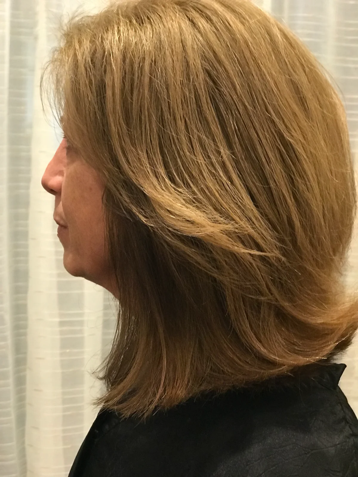 Layered blonde hairstyle photographed from the side